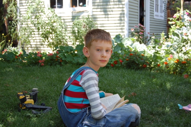 Emmett reading in the cool backyard shade.